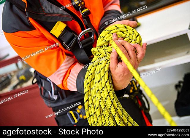 detail of the hands of a climber with the safety rope in hand