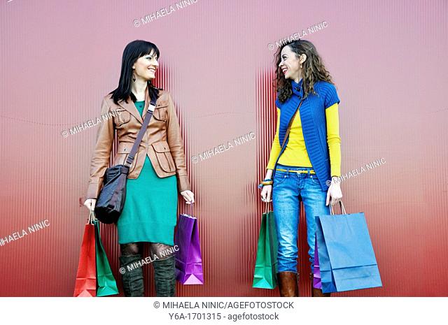 Two young women outdoors with shopping bags