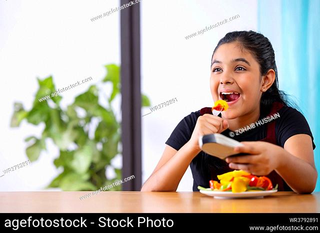 Portrait of girl eating healthy vegetable salad at home