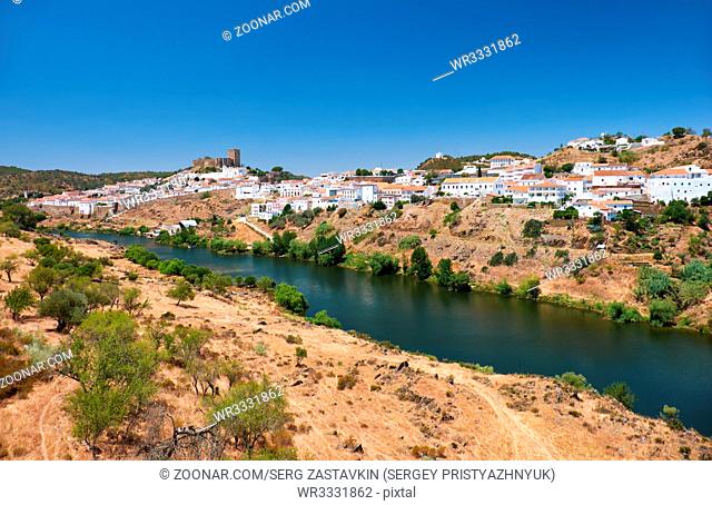 Mertola with the old mediaeval castle on the hill as viewed from the high opposite side of the Guadiana river. Baixo Alentejo. Portugal
