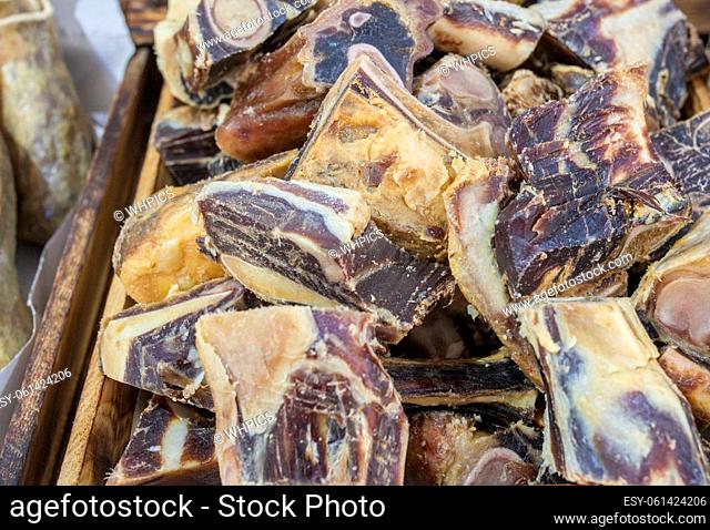 Iberian cured hambone displayed at street market stall. Selective focus