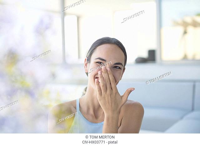 Laughing brunette woman covering mouth