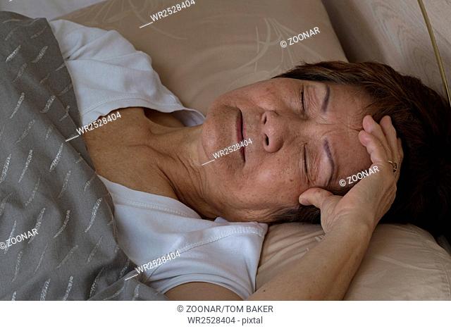 Senior woman having difficulty falling asleep at nighttime