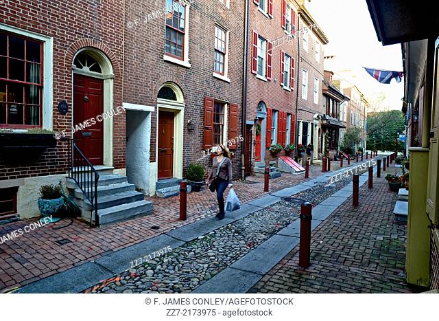 A resident walks through Elfreth's Alley, the oldest, continuously occupied neighborhood in the original United States
