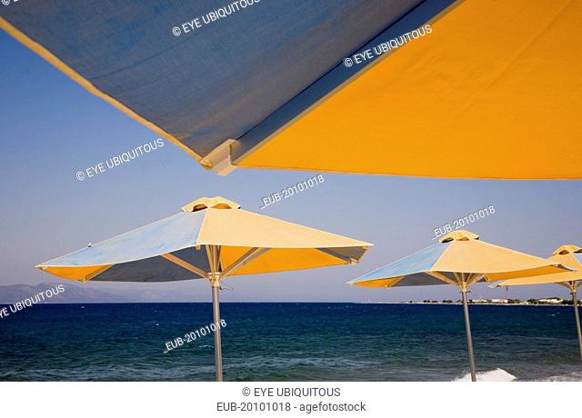 Blue and yellow striped parasols on beach outside Kos Town