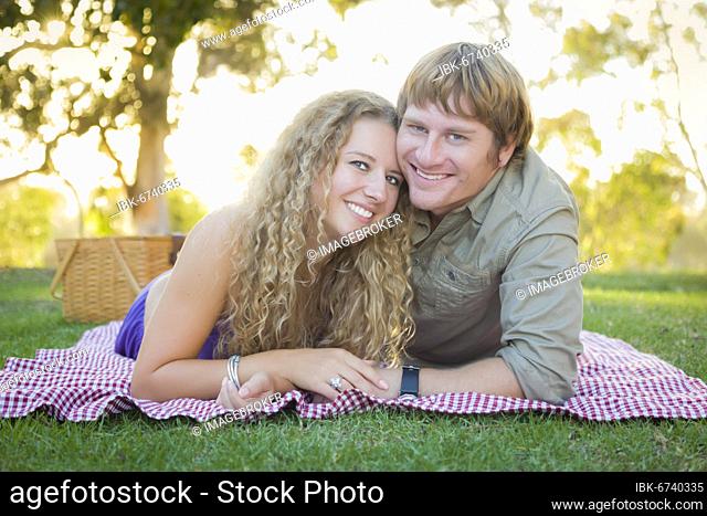 Happy attractive loving couple portrait in the park