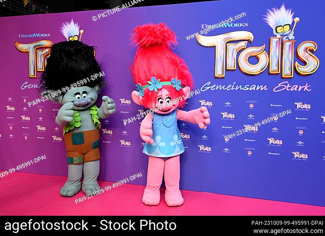 08 October 2023, North Rhine-Westphalia, Cologne: red carpet with the characters Branch and Poppy, l-r, to the premiere of Animaltion film Trolls 3 - Strong...