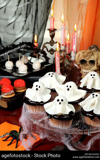 Smorgasbord ?upcakes in chocolate glaze decorated marzipan ghosts on Halloween