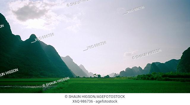 A valley in the Guangxi countryside with the Guilin mountains in China in Asia Far East