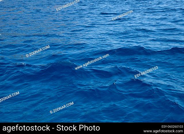 Indigo blue sea water surface with ripples and waves, high angle view