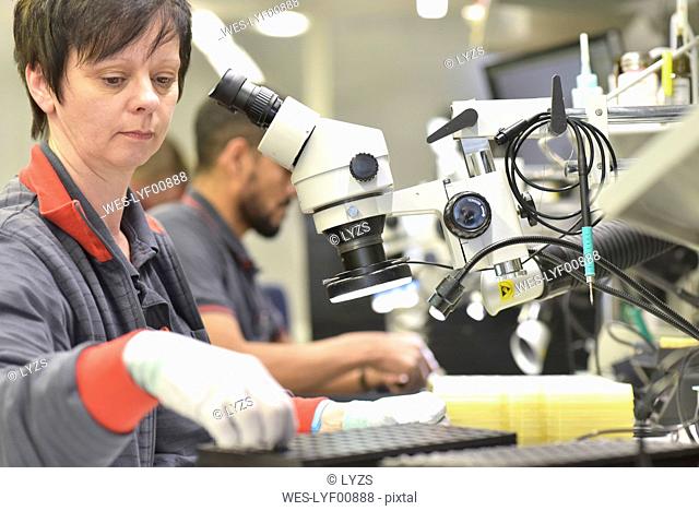 Woman working on quality control in the manufacturing of circuit boards for the electronics industry