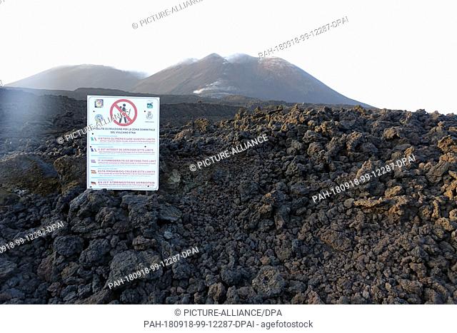 07 September 2018, Italy, Etna: On a boulder field of lava rock on Etna, there is a sign prohibiting to continue without volcanologists