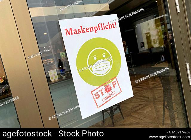 Information sign at an entrance gate to an organic market: MASKENKFLICHT-STOP CORONA. Closed shopping mall due to corona pandemic, shopping center