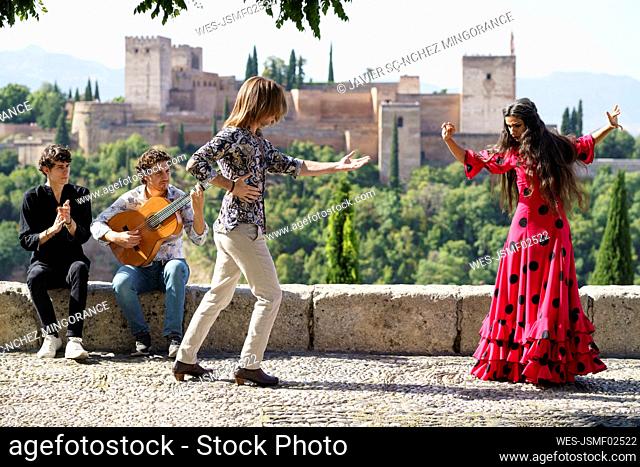 Flamenco dancers and guitarist performing in front of Alhambra, Granada, Spain
