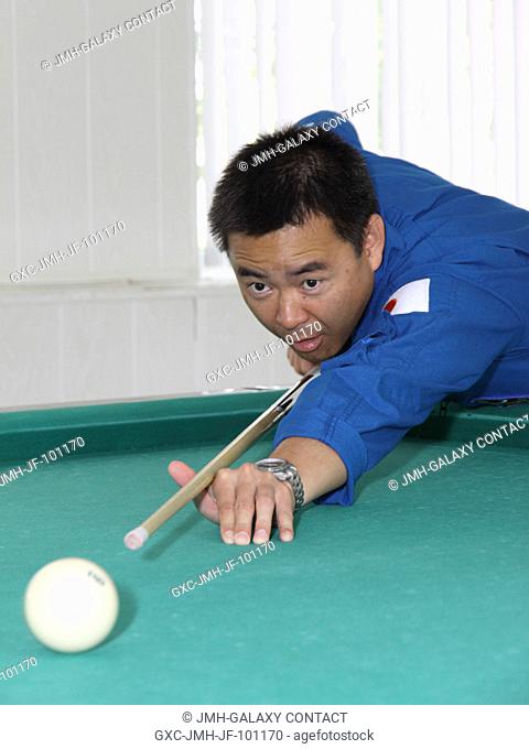 Expedition 3233 Flight Engineer Aki Hoshide of the Japan Aerospace Exploration Agency gets in a round of billiards at the Cosmonaut Hotel crew quarters in...
