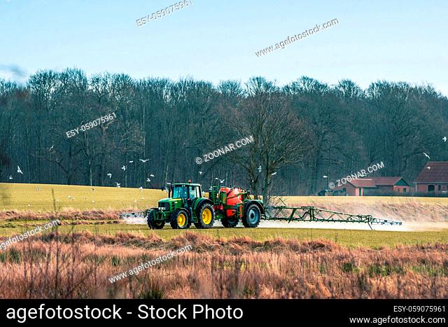 Tractor driving aroung on a field with fertilizer
