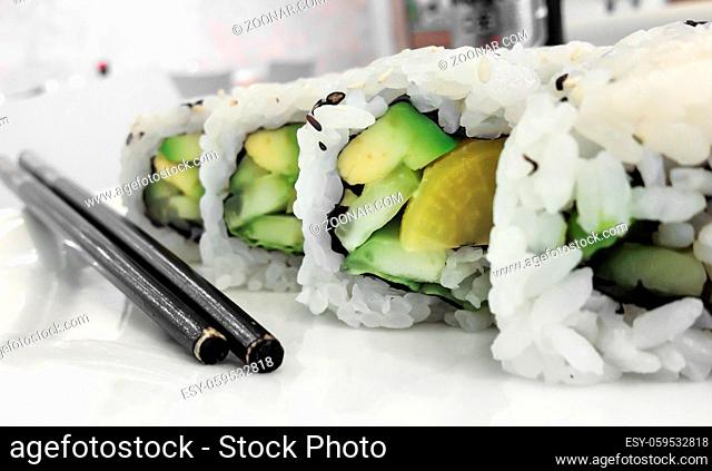 Japanese cuisine. Closeup of fresh veggie maki rolls with avocado
