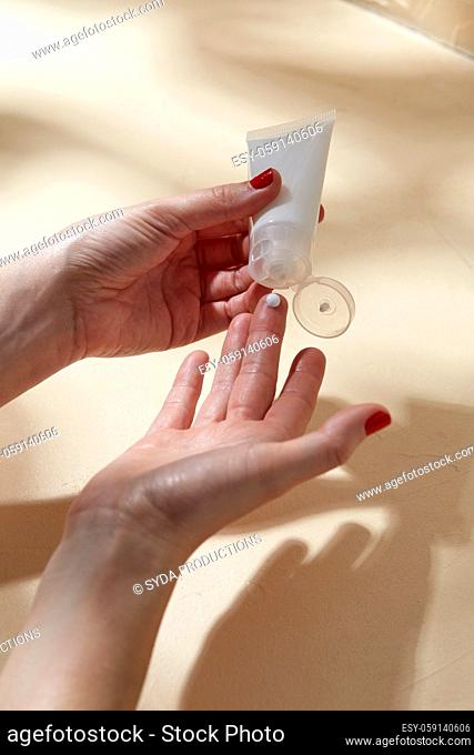 female hands applying moisturizer to skin