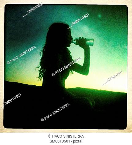 Silhouette of girl drinking in Ibiza, Balearic Islands, Spain