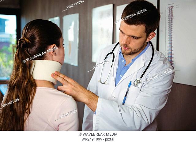 Physiotherapist examining a female patient's neck