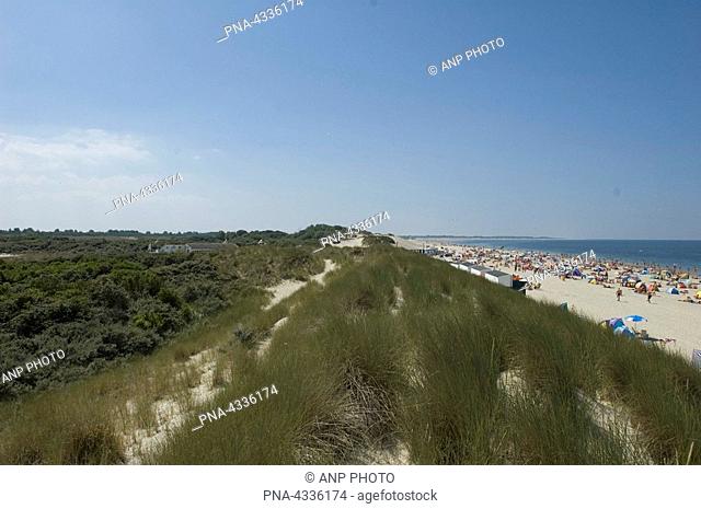 The dunes and the beach with sunbathers on a sunny day