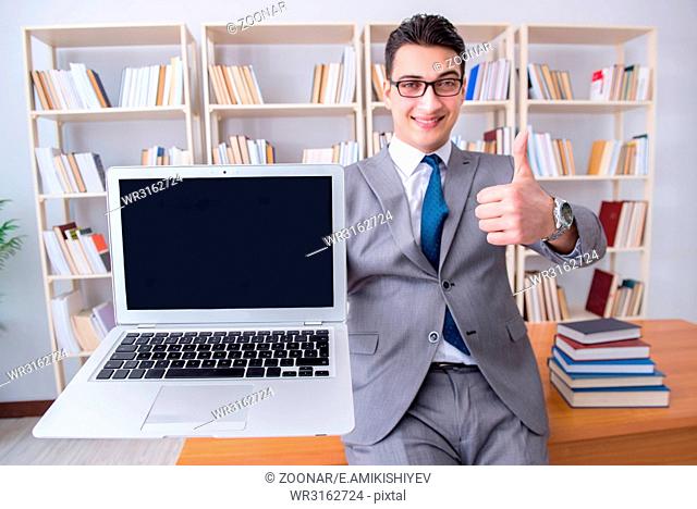 Businessman with a blank screen laptop working in the library