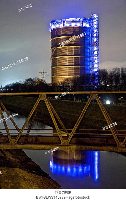 Emscher River with the spectacular illuminated Gasometer at night, Germany, North Rhine-Westphalia, Ruhr Area, Oberhausen