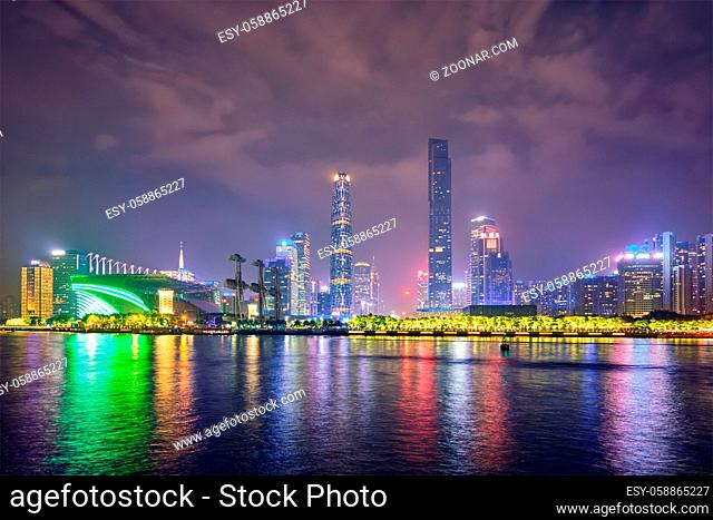Guangzhou cityscape skyline over the Pearl River illuminated in the evening. Guangzhou, China
