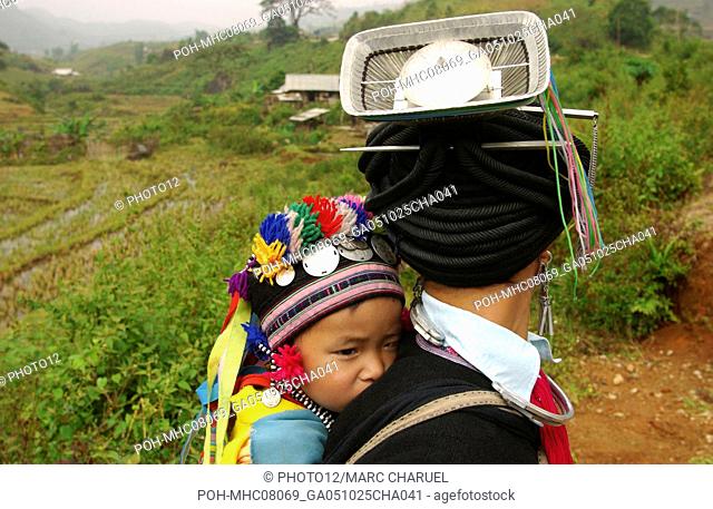 Behind view of a woman of Dao Red ethnic minority with her child at the village of Lai Chau 2005