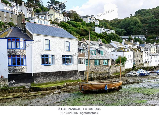 boat aground and old houses, Polperro, cityscape of the touristic village on southern coast of Cornwall with low tide in the river harbour and boats aground