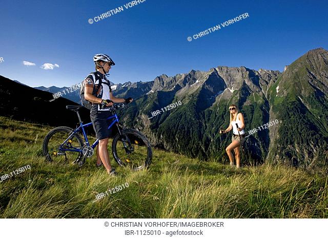 Mountain biker and a hiker, Zillertal Alps, Mayerhofen, North Tyrol, Austria, Europe