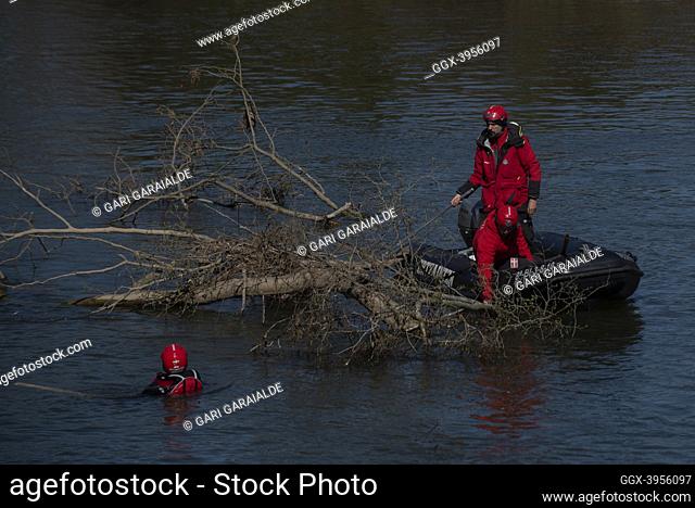 Members of the Basque autonomous police search for the body of an irregular migrant who supposedly drowned while trying to cross the river