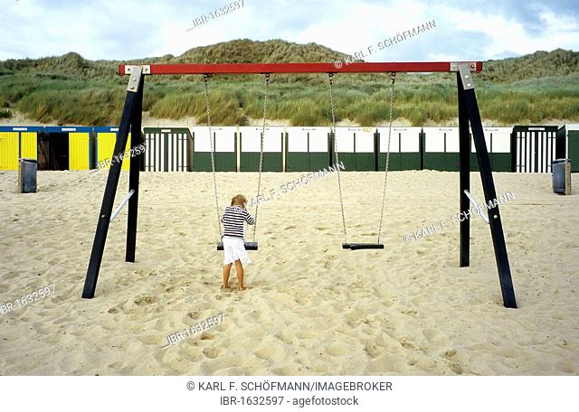 Little girl playing on a swing on the empty beach, Zoutelande, Walcheren peninsula, Zeeland province, Netherlands, Benelux, Europe
