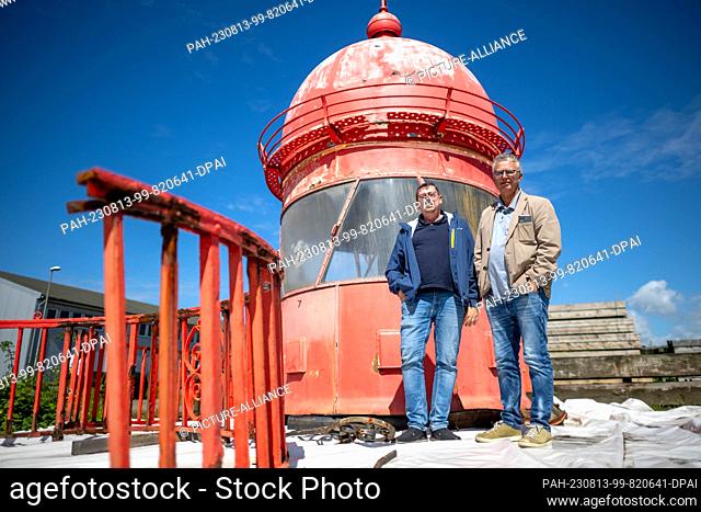 PRODUCTION - 10 August 2023, Bremen, Bremerhaven: Matthias Koch (l) and Holger Bruns from Bremenports stand in front of the dome of the Mole Tower