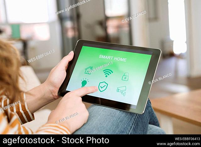 Close-up of woman using digital tablet with smart home app