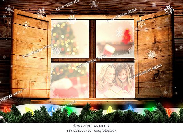 Composite image of cheerful mother and daughter with christmas gift against white background