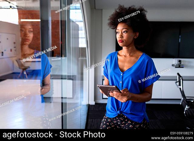 African american business woman in meeting room standing over blueprint document