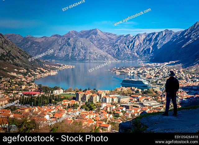 Tourist with a hat admiring the stunning landscape of the Bay of Kotor in Montenegro as seen from the road to Lovcen National Park