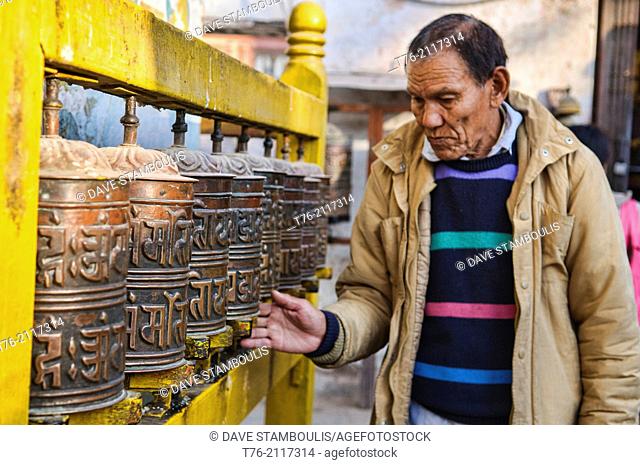 Tibetan pilgrim and prayer wheels at the Boudhanath Stupa in Kathmandu, Nepal