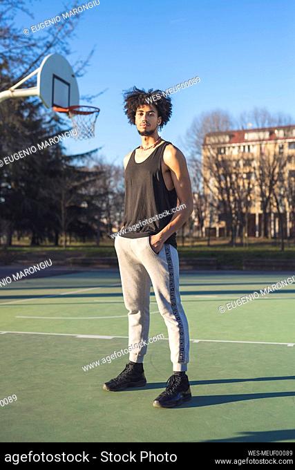 Portrait of young man standing on basketball court