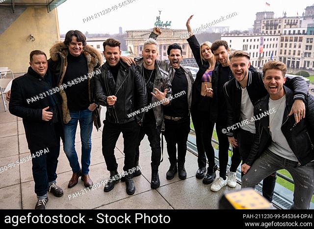 30 December 2021, Berlin: The band ""Team 5ünf"" and the band ""Glasperlenspiel"" stand on the terrace of the Academy of Arts in front of the Brandenburg Gate...
