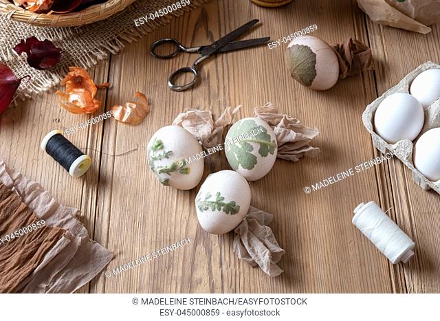 Preparation of Easter eggs for dying with onion peels with a pattern of herbs and flowers