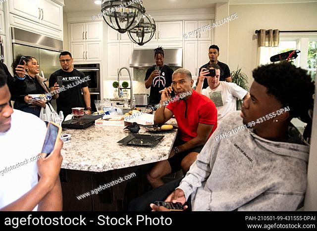 01 May 2021, US, Lake Forest: German-American football player Amon-Ra St. Brown (M) talks on the phone with Detroit Lions representatives