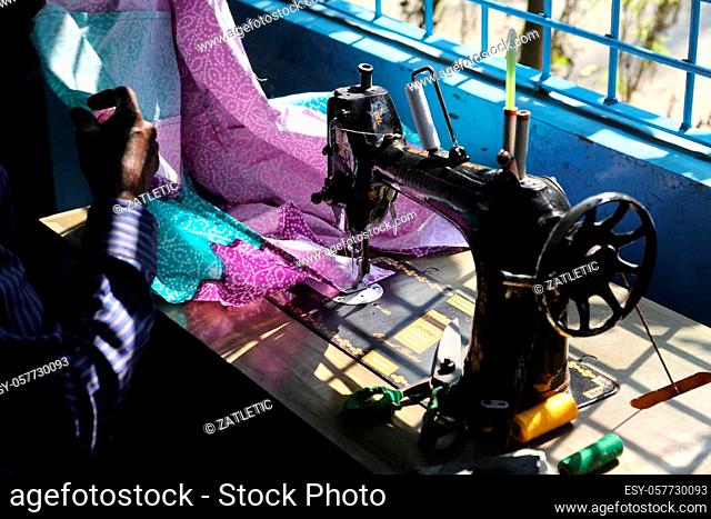 Man is working with sewing machine in Kumrokhali, West Bengal, India