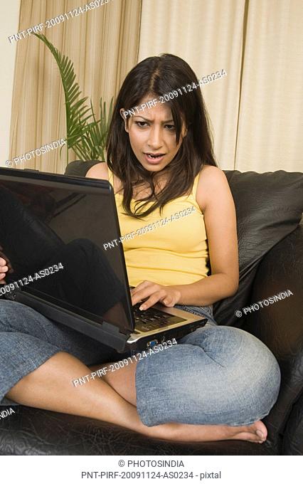 Woman looking surprised while using a laptop
