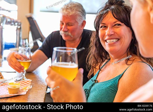 Group of friends enjoying glasses of micro brew beer at bar