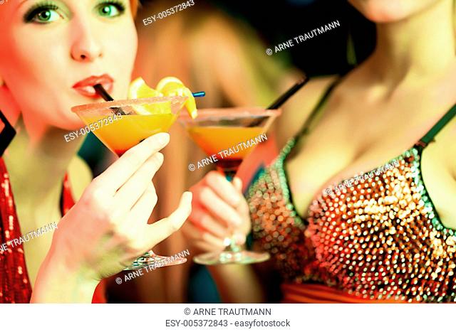 Frauen in einem Club trinken Cocktails