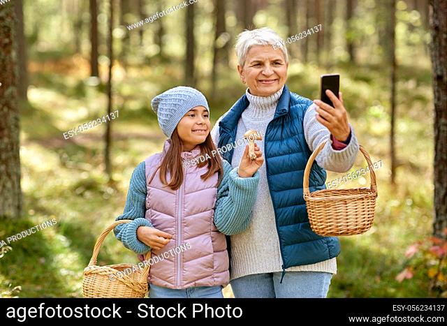 grandma with granddaughter taking selfie in forest