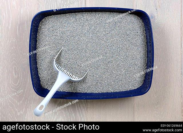 A top view of a blue cat litter tray and scoop