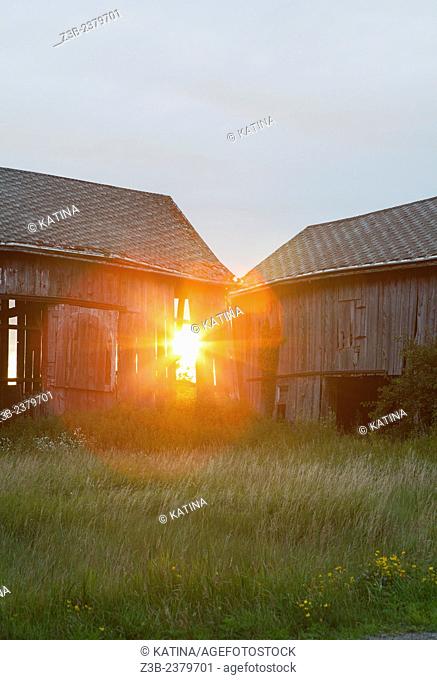 Sunset shines through an old barn in the countryside of Mount Pleasant, Michigan, MI, USA
